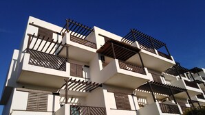 A multi-story building with balconies, white walls, and brown window shutters. - Résidence Mirador Golf Cabo Negro (M'diq)
