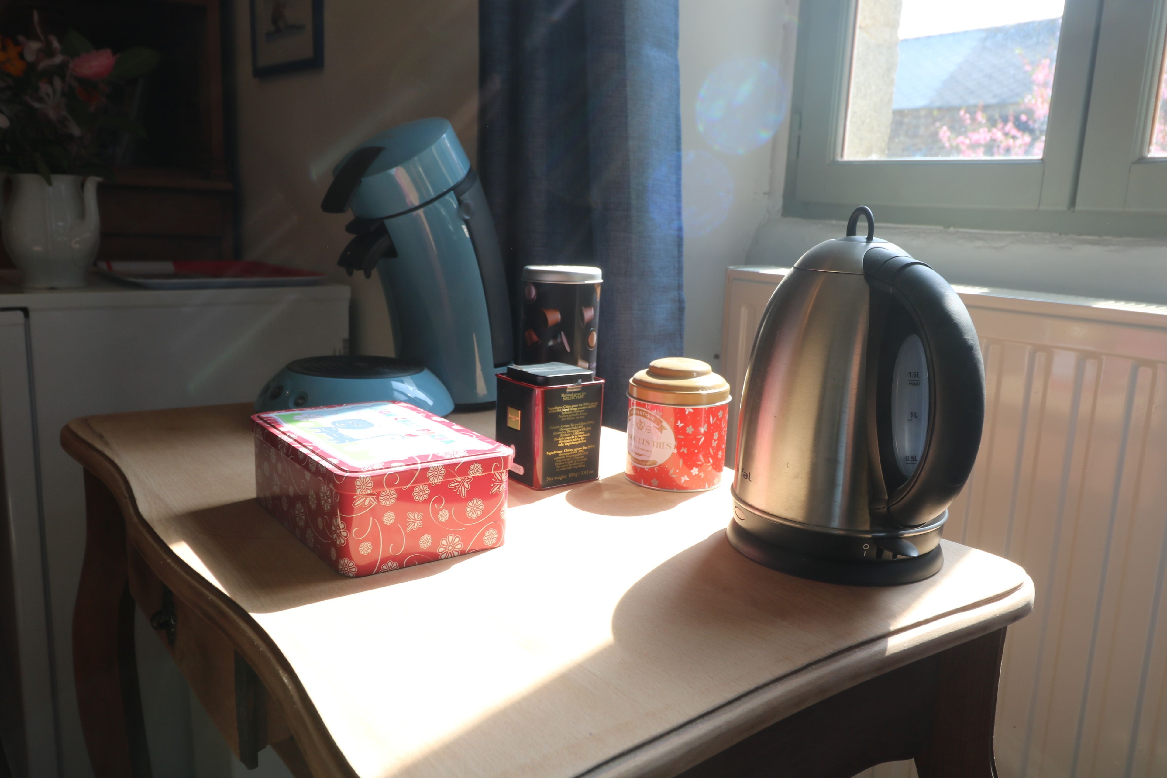 Una mesa con una tetera, una caja y un recipiente.