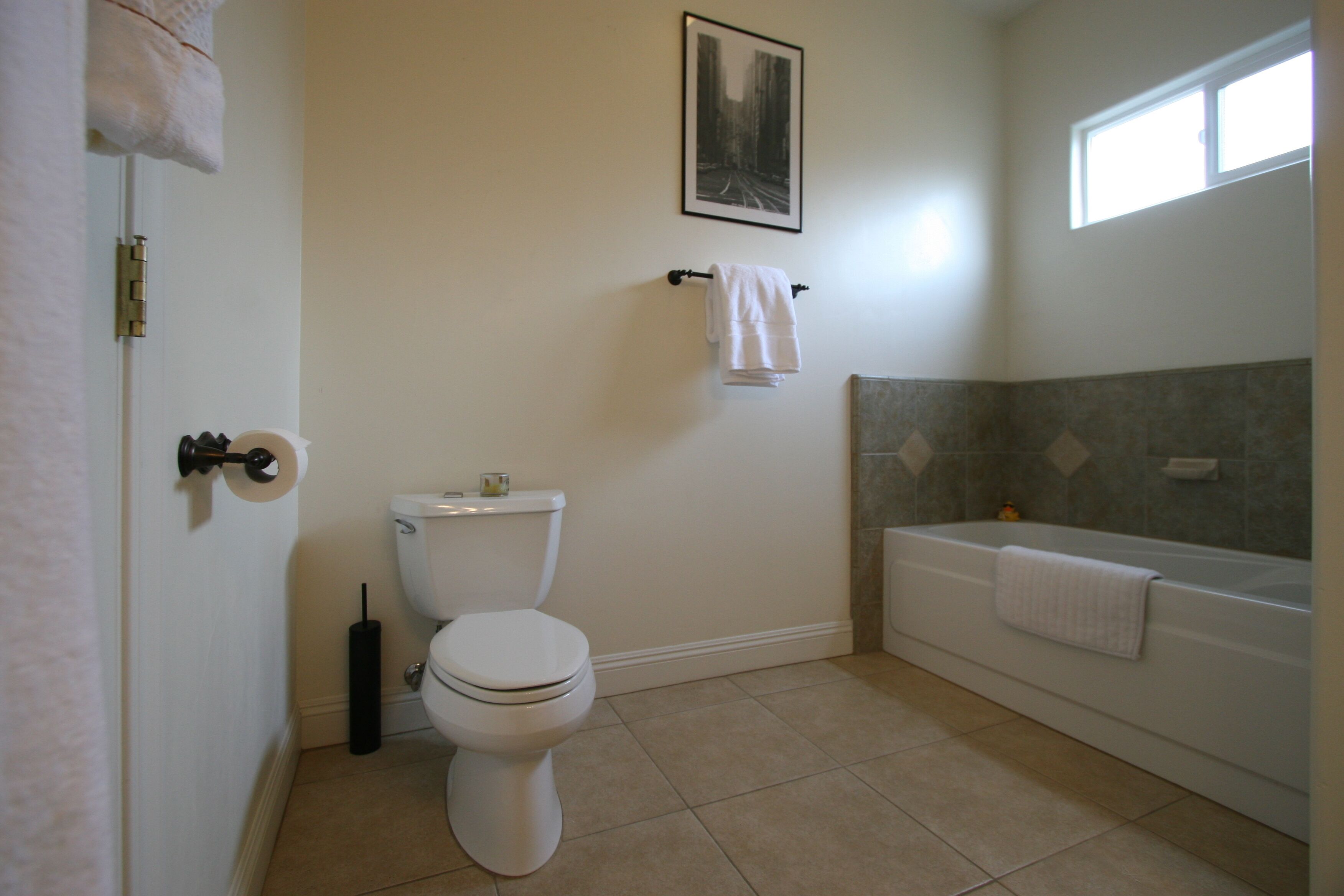 A bathroom with a toilet, a bathtub, and a towel rack.