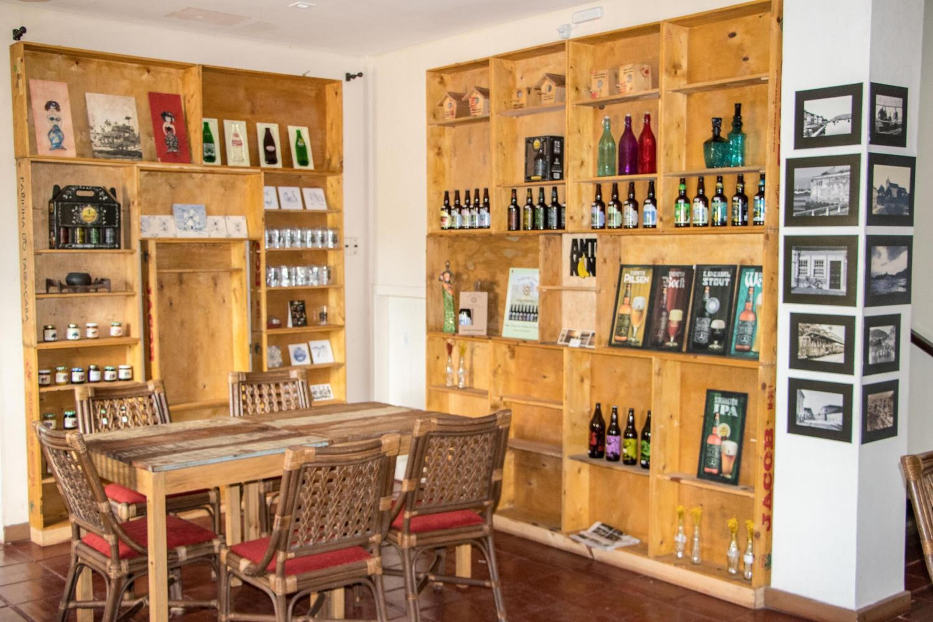 Un comptoir en bois avec des étagères remplies de bouteilles et des tableaux encadrés.