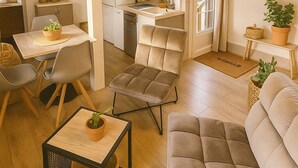 Un salón amplio con una mesa de comedor, dos sofás, una mesa baja y una cocina al fondo.