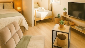 Un dormitorio acogedor con cama, mesita de noche, lámpara, televisor y una pequeña mesa con plantas.