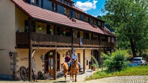 A traditional building with a wooden balcony, stone walls, and a cobblestone ground. - Landhotel Gut Wildberg (Klipphausen)