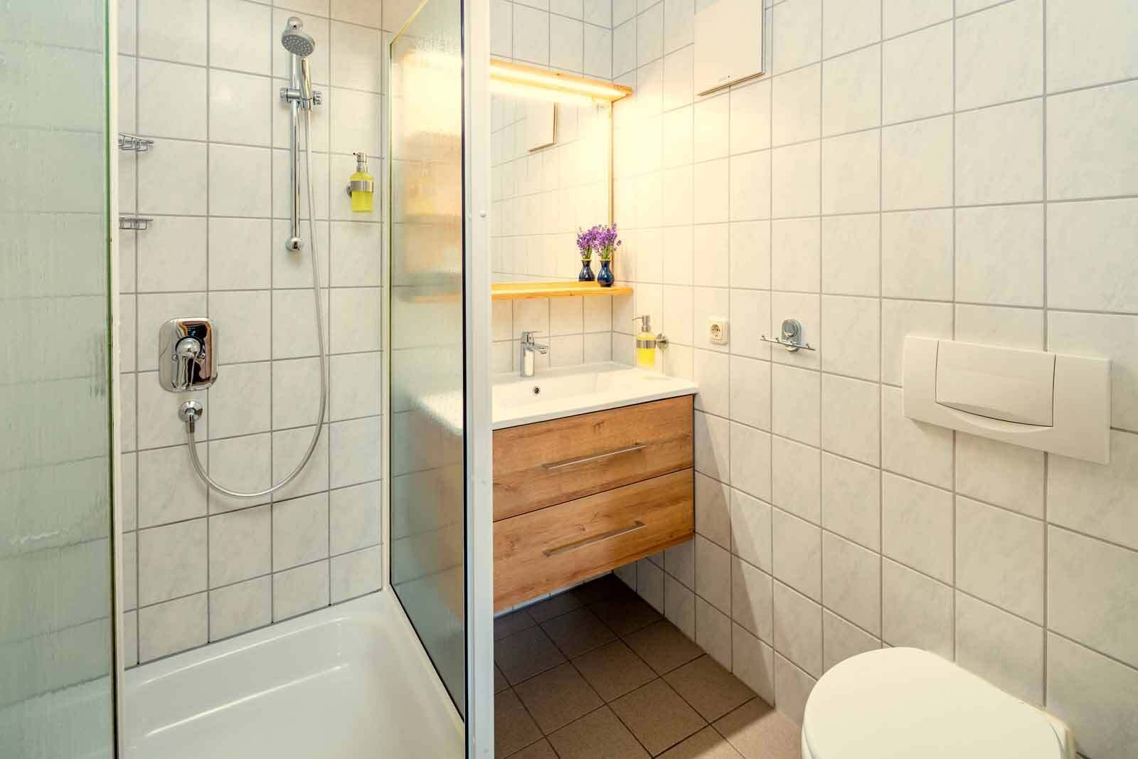 A bathroom with a shower, toilet, and sink.