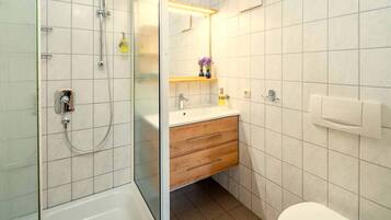 A bathroom with a shower, toilet, and sink.