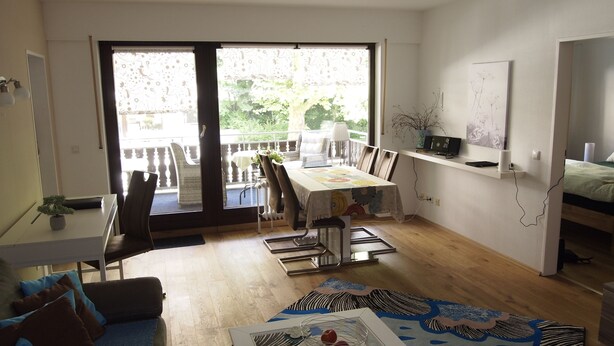 A compact living space with a dining area, a sofa, a coffee table, and a bed. - Ferienwohnung AltesSalzwerk (Bad Harzburg)
