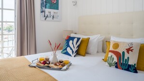 A hotel room with a bed, breakfast tray, and a painting on the wall. - Hôtel La Tour de Nesle La Rochelle Vieux Port (La Rochelle)