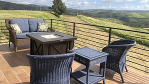 A terrace with wicker furniture, a table, and a sofa with cushions. - Casa Tranquila Puerto Nuevo with Ocean and Mountain View that Sleeps 20 (Puerto Nuevo)