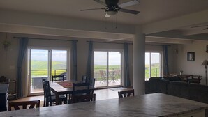 A spacious living area with a large dining table, a sofa, and a ceiling fan. - Casa Tranquila Puerto Nuevo with Ocean and Mountain View that Sleeps 20 (Puerto Nuevo)