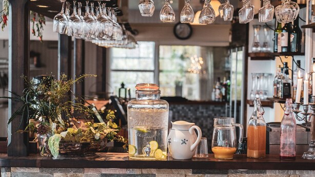 A bar area with a variety of glassware, a large jar, a pitcher, and a candle holder. - Turistgården - House Of Ven (Sankt Ibb)