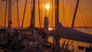 A marina at sunset with multiple sailboats docked. - Turistgården - House Of Ven (Sankt Ibb)