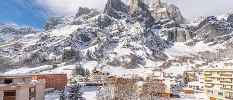 Un paysage montagneux enneigé, avec une ville au premier plan.