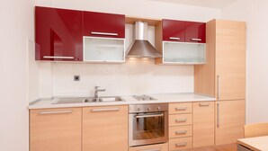 Una cuina moderna amb armaris de fusta, un forn d'acer inoxidable i un doble rentaplat.
