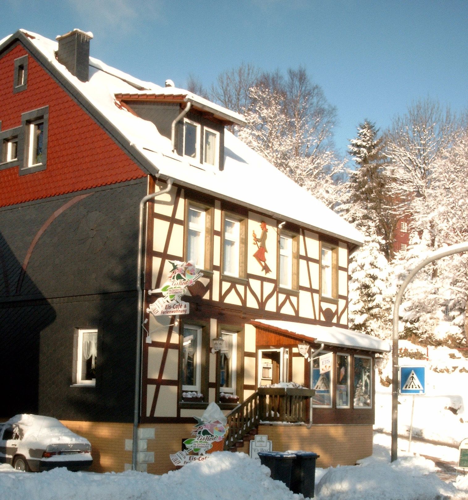 A two-story building with a red facade and a balcony.