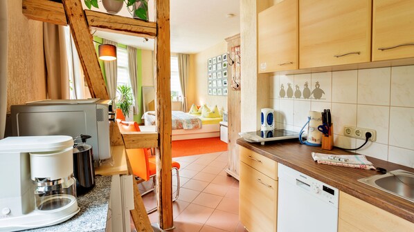 A compact kitchen with a coffee maker, a Siemens dishwasher, and wooden cabinets.