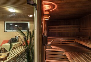 Relax in a serene sauna with a clear view, wooden benches, and a warm ambiance.