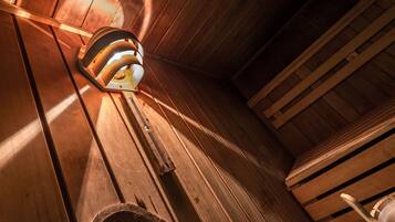 Een houten plafond met een lamp en een metalen object.