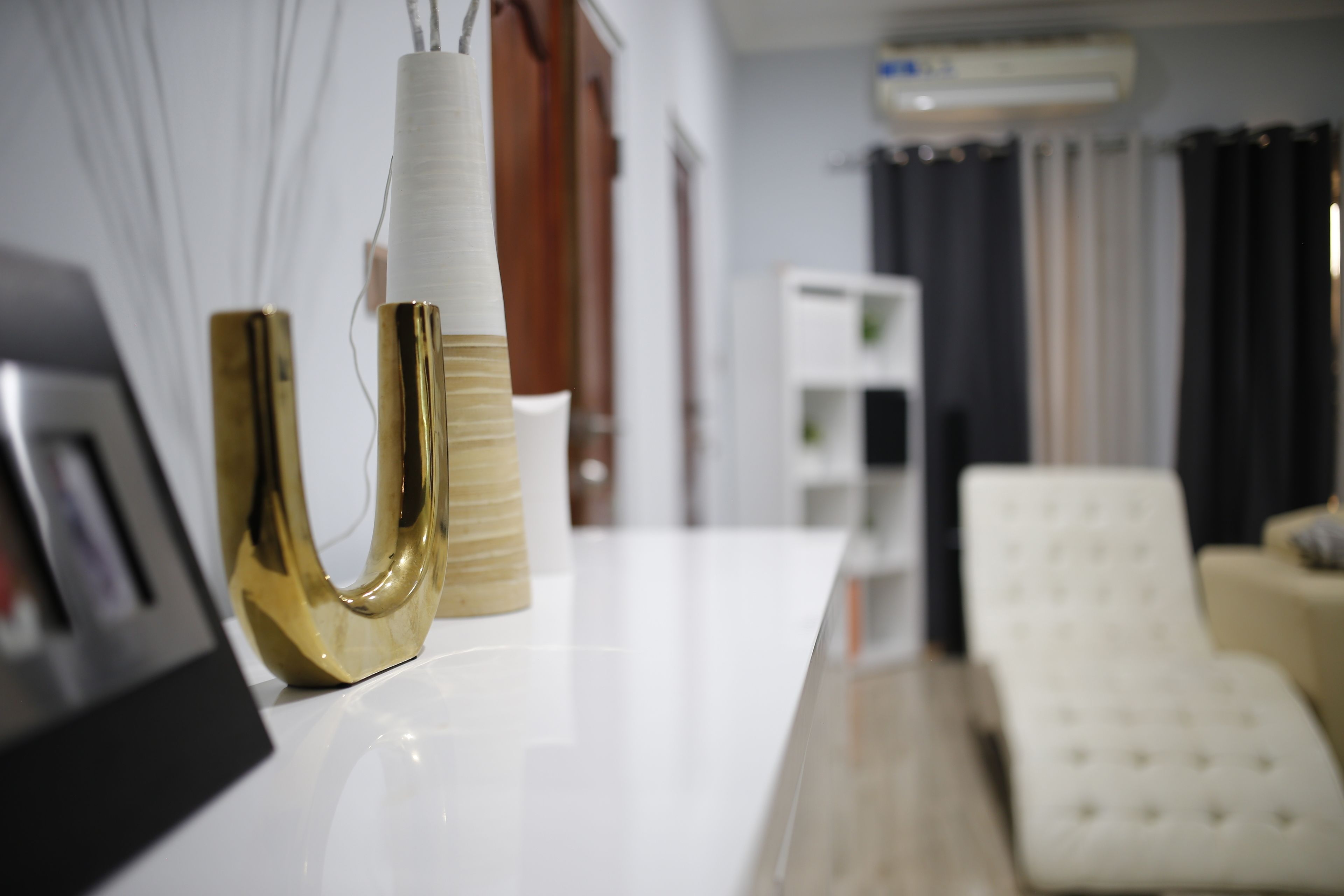 A modern living room with a white sofa, a coffee table, and a decorative vase.