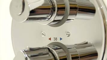 A chrome faucet with a temperature control knob and a water flow control knob.