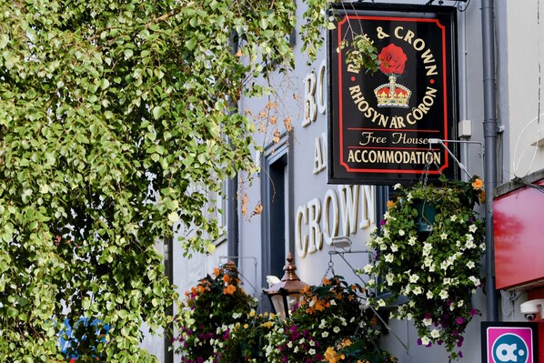 A building with a sign reading "B & CROWN & CORON Accommodation" and a red crown emblem.