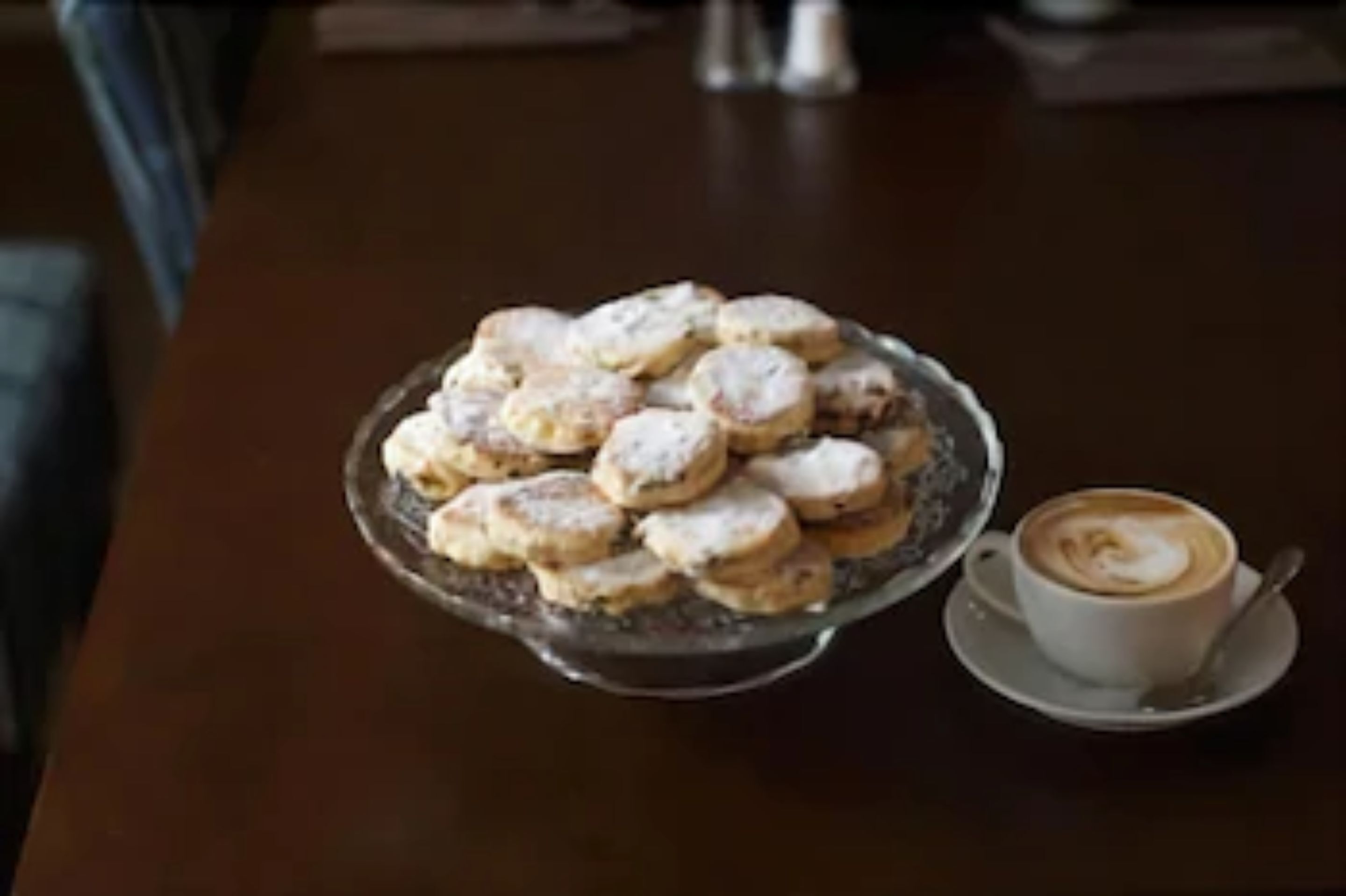 A plate of cookies and a cup of coffee on a table.