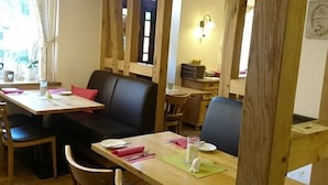En matplats med ett träbord, svarta läderbeklädda sittplatser och en träavskärmning.