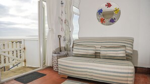 Une pièce avec un lit, un petit tapis, une barrière blanche et un mur orné d’un miroir en forme de poisson.