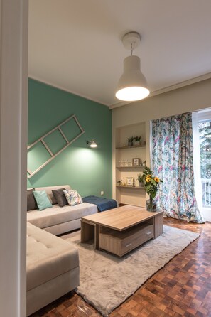 A living room with a sofa, coffee table, and a hanging light fixture.