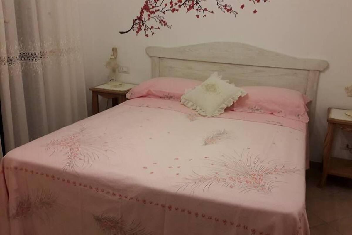 Ein Schlafzimmer mit einem Bett, zwei Nachttischen und einem Wandregal.