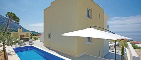 Een buitenzwembad, een verwarmd zwembad en parasols bij het zwembad