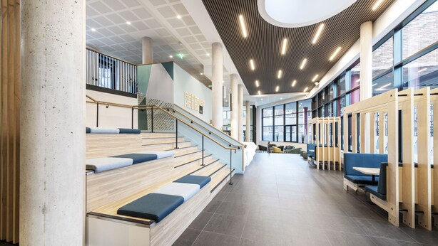 A spacious indoor area with a staircase, seating areas, and a modern ceiling design. - Yugo Explore - Ardcairn House (Dublin)