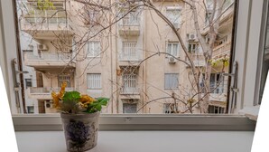 A potted plant on a windowsill with a view of a multi-story building. - Elite Gem in the heart of Kolonaki (Athens)