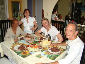 A group of people dining at a table with various dishes and drinks. - Departamento Privado Bea en Vedado (Havana)