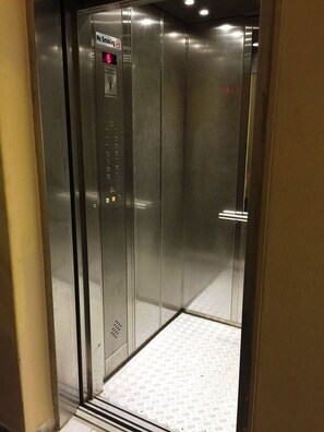 An elevator with a "No Smoking" sign, control panel, and metallic floor. - Departamento Privado Bea en Vedado (Havana)