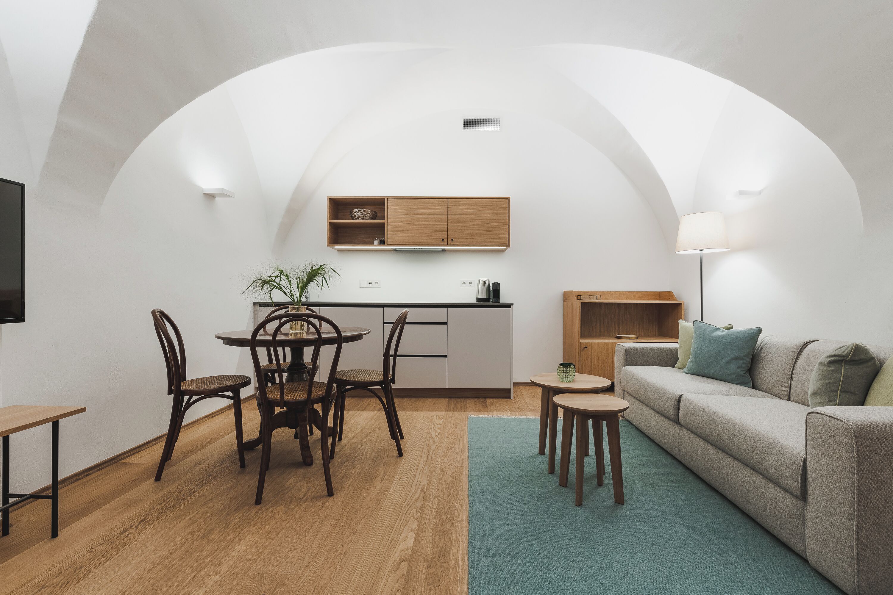 Un espace de vie compact comprenant une cuisine, un coin repas et un coin salon.