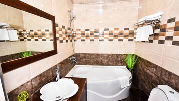 Un baño moderno con bañera, lavabo e inodoro.