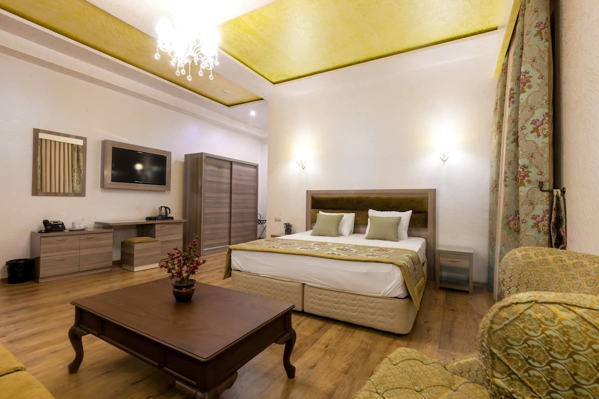 A bedroom with a bed, bedside table, and a desk area.