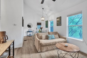 A modern living room with a sofa, coffee table, and dining area.