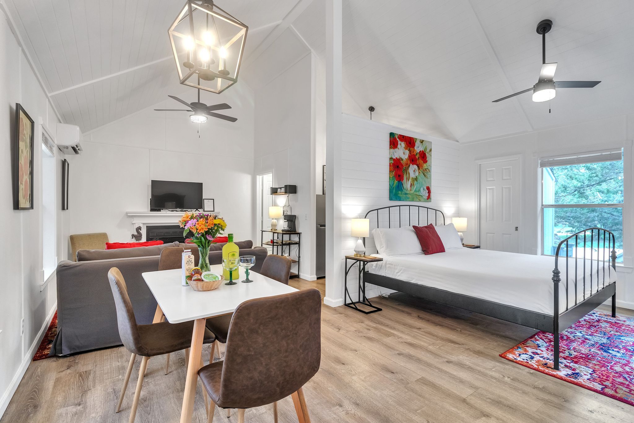 Une chambre moderne comprenant un lit, un bureau, une chaise et un coin repas avec une table et des chaises.