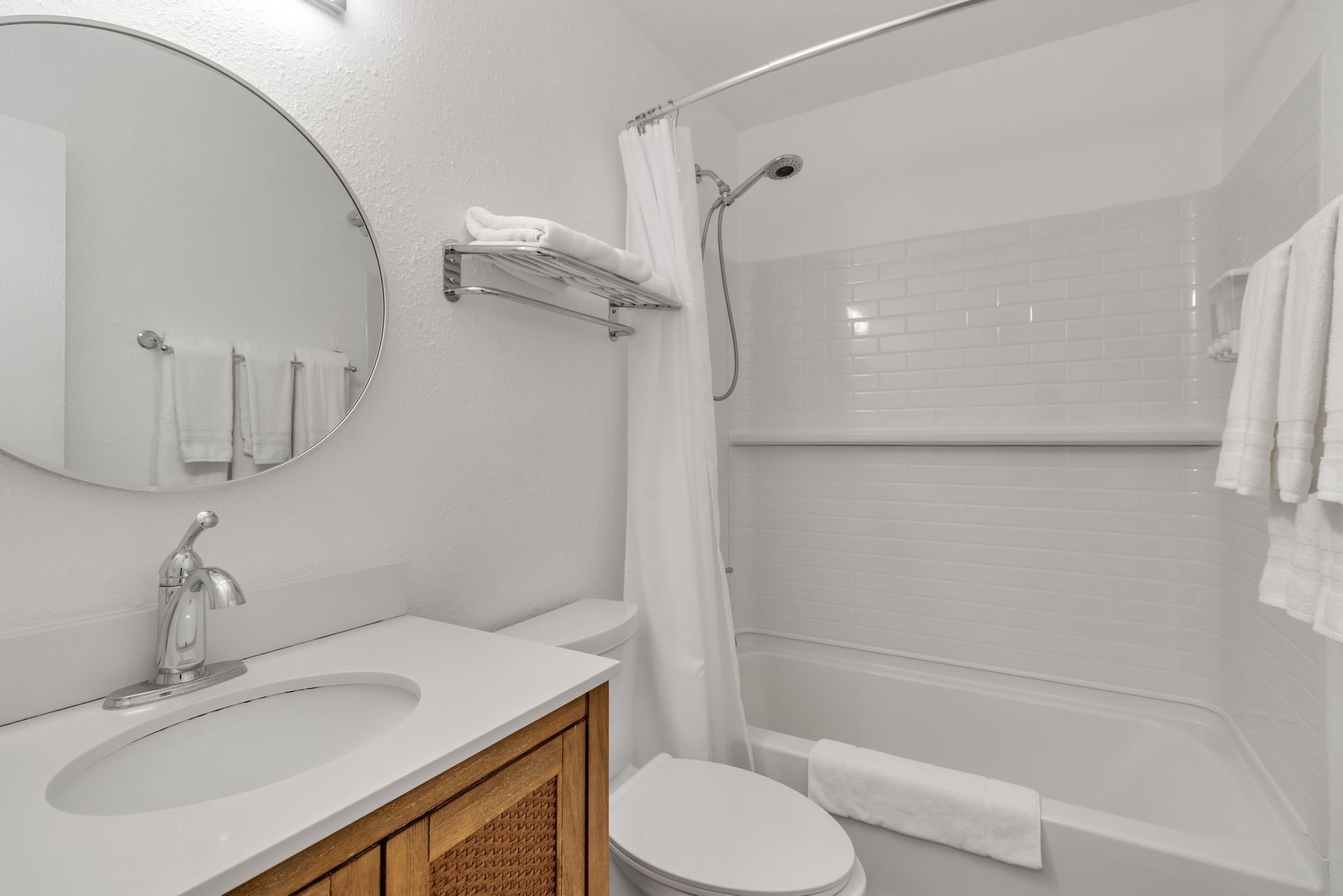 Un baño moderno con lavamanos, espejo, inodoro y ducha.