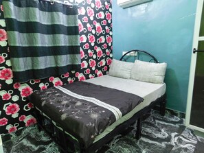 A bedroom with a bed, curtains, and a patterned wall. - Toprano Hotel (Lagos)