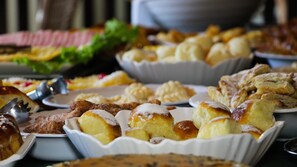 Une variété de produits de boulangerie est disposée sur une table, notamment des pâtisseries et du pain.