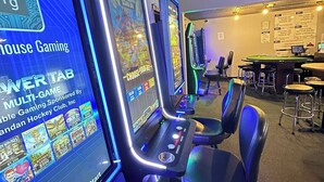 A gaming area with multiple arcade machines, chairs, and a bar area. - Days Inn by Wyndham Mandan Bismarck Area (Mandan)