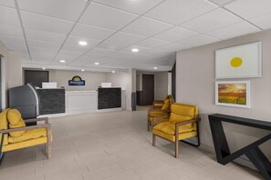 A reception area with a reception desk, a large window, and a wall-mounted artwork. - Days Inn by Wyndham Mandan Bismarck Area (Mandan)