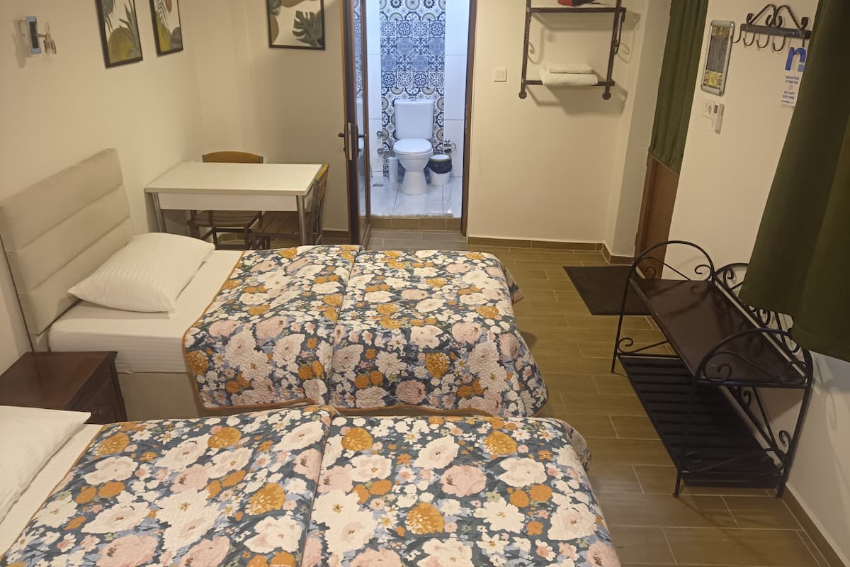 Une chambre avec deux lits, un bureau et une chaise.