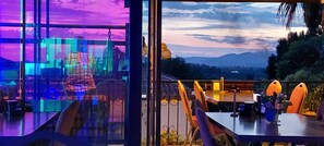 A dining area with a view of a cityscape and mountains.