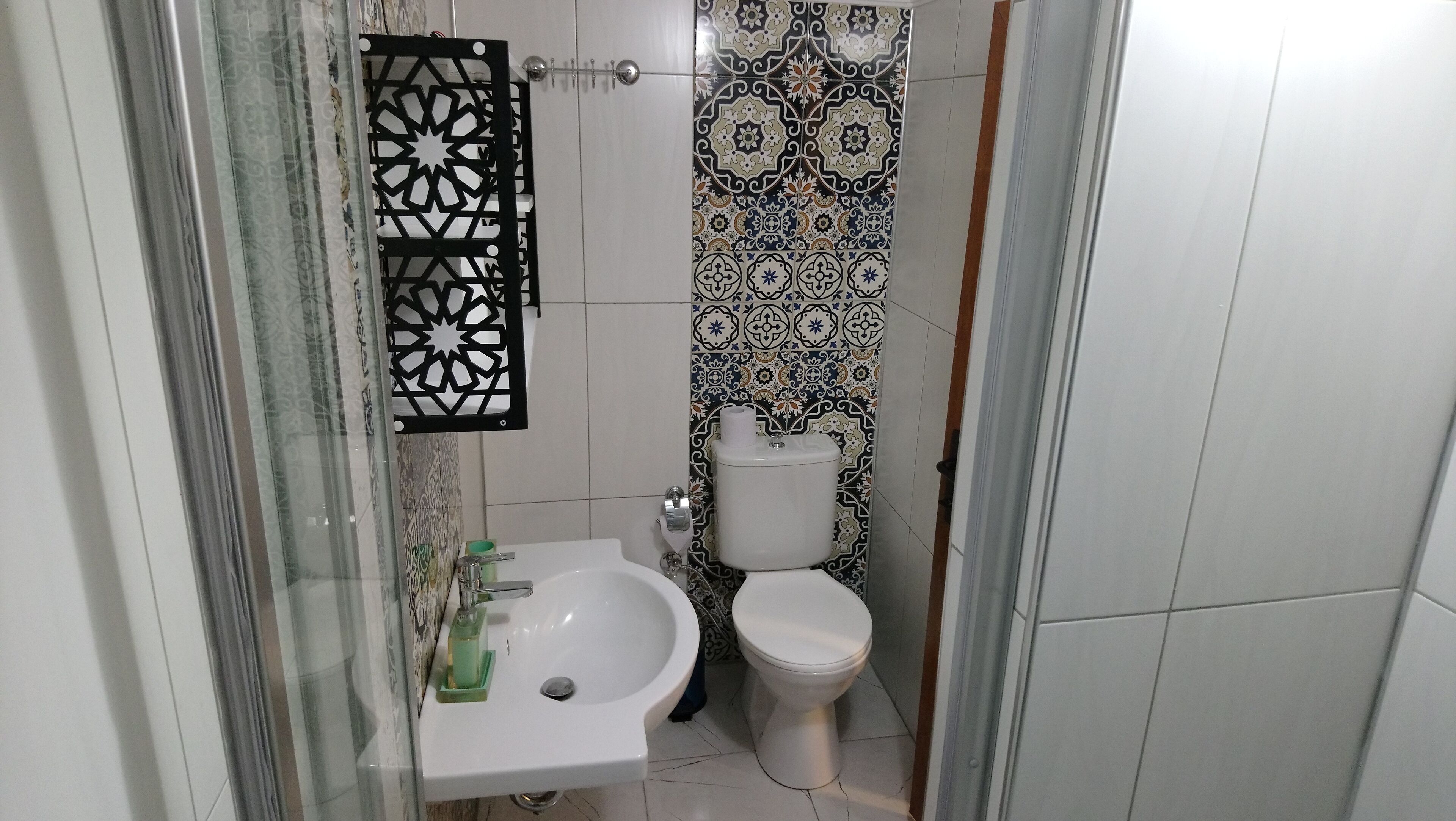 Un bany amb un rentamig, vàter i rajoles decoratives.