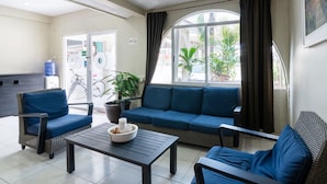 Un coin salon comprenant un canapé, deux fauteuils et une table.
