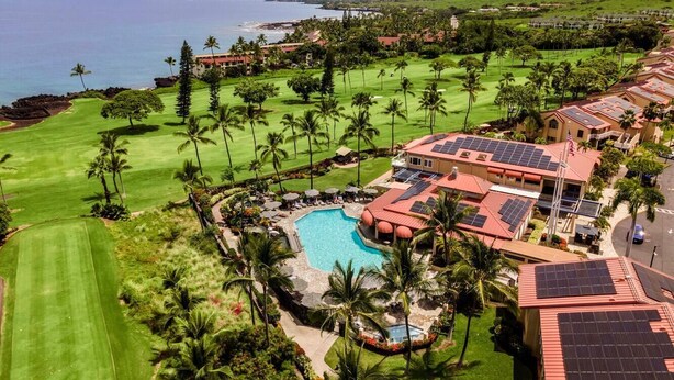 A golf course with a swimming pool, palm trees, and a view of the ocean. - Kona Coast Resort at Keauhou Gardens 8204 (Kailua-Kona)