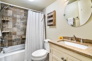 A bathroom with a bathtub, toilet, and sink. - Casa De Emdeko 219 (Kailua-Kona)